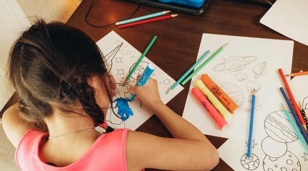 Little girl colors a drawing book