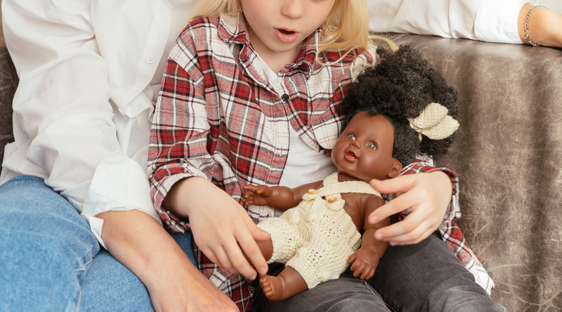 white girl playing a african girl doll